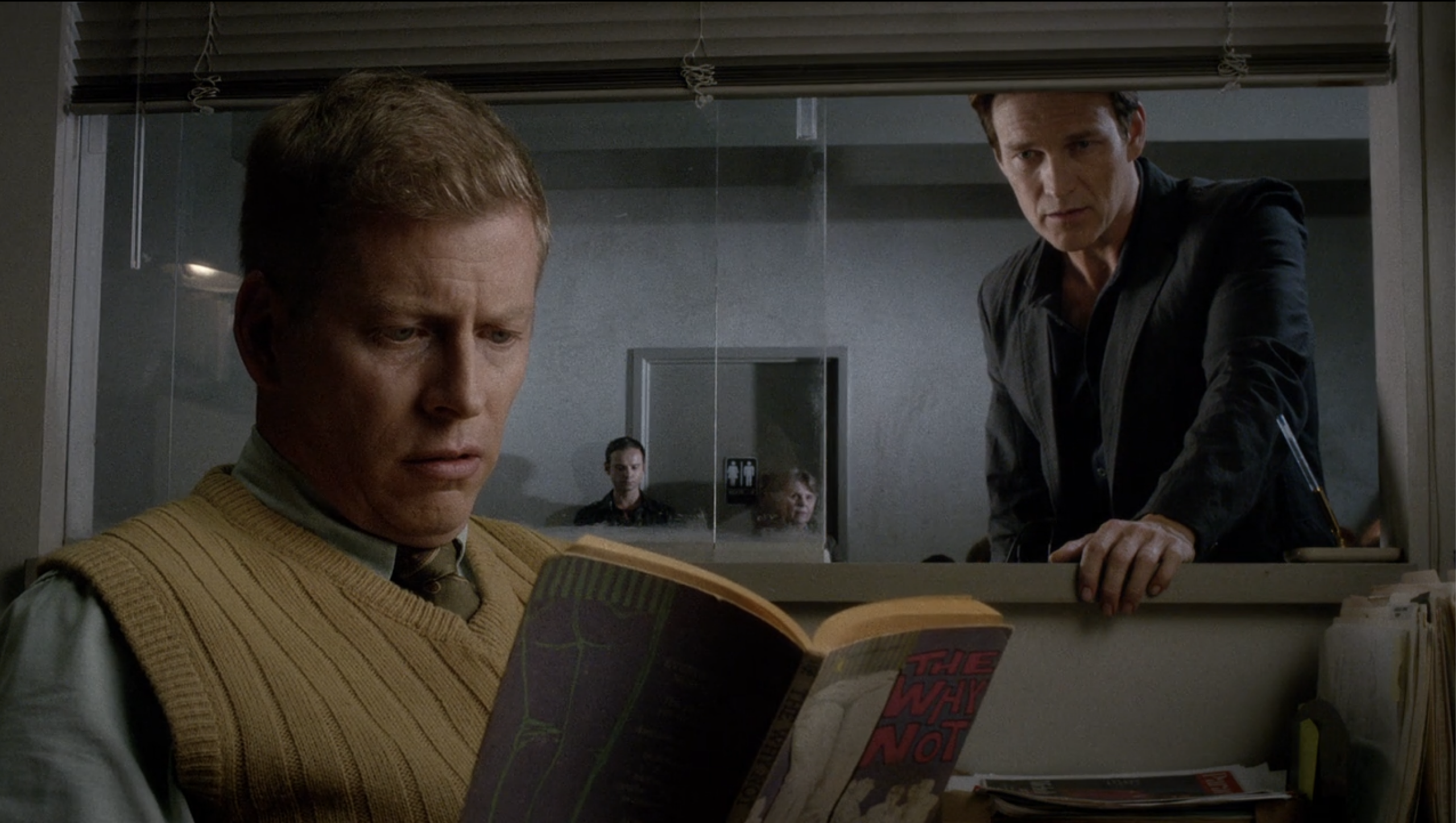 Screenshot from season 7, episode 6 of True blood featuring a receptionist reading a first edition copy of The Why Not by Victor J. Banis.